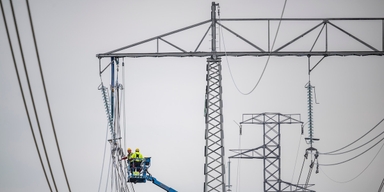 Montörer i arbete med att dra nya 400 kVolt högspänningskablar i ledningsstolpar. I höst ser vi ut att få dras med högt elpris.